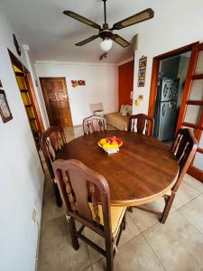 Un comedor con mesa y sillas de madera. en Dpto a pasos de la peatonal, en Villa Carlos Paz