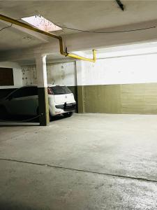 un garaje con un coche blanco aparcado en él en Dpto a pasos de la peatonal, en Villa Carlos Paz