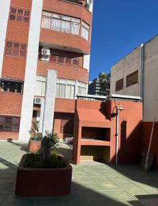 un edificio alto de ladrillo con una escalera delante de él en Dpto a pasos de la peatonal, en Villa Carlos Paz