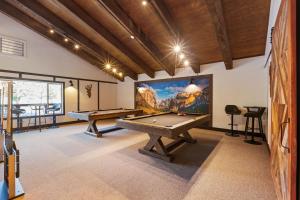 een speelkamer met twee pooltafels en een groot scherm bij Yosemite Lakes Bunkhouse Cabin 27 in Harden Flat