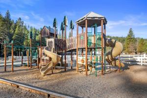 een speeltuin met een glijbaan en een glijbaan bij Yosemite Lakes Bunkhouse Cabin 27 in Harden Flat
