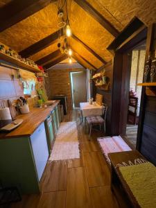 a large kitchen with a counter and a table at Vikendica RANKOVIĆI in Mokra Gora