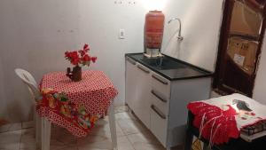 una piccola cucina con un tavolo e un bancone con un tavolo e una stufa di House in Caldas do Jorro a Tucano