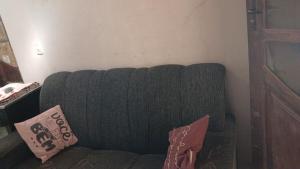 un divano verde in un soggiorno con due cuscini di House in Caldas do Jorro a Tucano