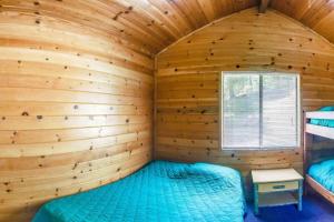 een blokhut met een bed in een kamer bij Yosemite Lakes Bunkhouse Cabin 27 in Harden Flat
