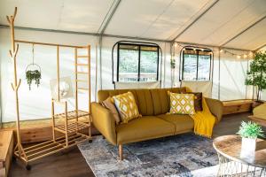 a living room with a couch in a tent at The Goldfinch's Nest - Glamping Tent with AC in Rogers +44 photos