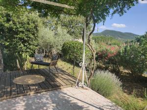 eine Terrasse mit einem Tisch und einem Stuhl auf einer Terrasse in der Unterkunft Villa Caroux in Bédarieux