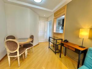 a living room with a table and a desk at Flat luxo, Janela Antirruído, Garagem, serviços in São Paulo