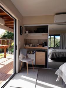 a room with a kitchen and a bedroom with a bed at Dover Terrace in Kaikoura