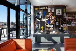 a living room with a couch and shelves of books at citizenM Boston North Station in Boston +38 photos