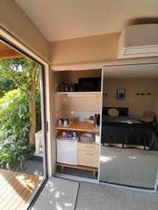 a small caravan with a bed and a kitchen at Dover Terrace in Kaikoura +29 photos