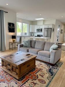 een woonkamer met een bank en een salontafel bij Modern, Cheerful 2 Bdrm Ohana Vacation Cottage in Kelowna