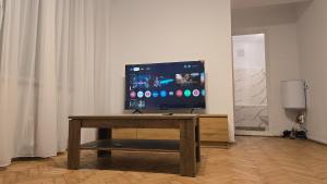 TV de pantalla plana sobre una mesa de madera en Shakespeare Central Apartment, en Craiova