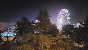 Una noria en una ciudad por la noche en Shakespeare Central Apartment, en Craiova