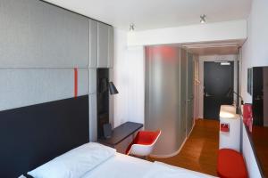 a bedroom with a bed and a red chair at citizenM San Francisco Union Square in San Francisco