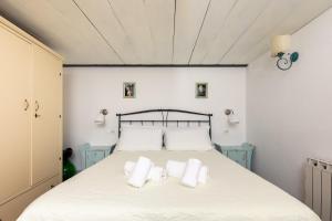 a bedroom with a bed with white sheets and pillows at Fabio Apartments San Gimignano in San Gimignano