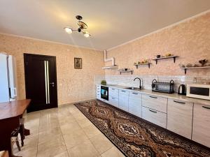 eine große Küche mit einem Waschbecken und einem Tisch in der Unterkunft У Лариси in Solotschyn