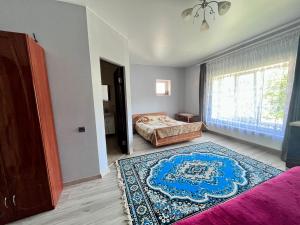 ein Schlafzimmer mit einem Bett und einem Teppich auf dem Boden in der Unterkunft У Лариси in Solotschyn
