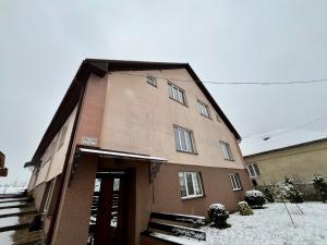 ein großes Gebäude mit einer Tür im Schnee in der Unterkunft У Лариси in Solotschyn