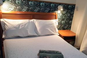 un dormitorio con una cama con sábanas y almohadas blancas en Apartamento Moderno com vista para á principal, en Volta Redonda