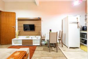 una pequeña sala de estar con mesa y nevera. en Apartamento Moderno com vista para á principal, en Volta Redonda