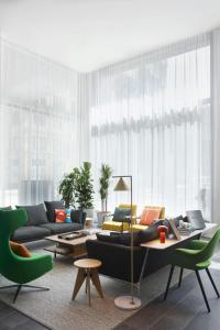 ロサンゼルスにあるcitizenM Los Angeles Downtownのリビングルーム(黒いソファ、緑の椅子付)
