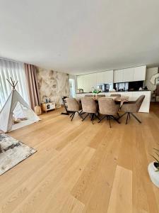 een woonkamer met een tafel en stoelen bij Am apartment in Pristina