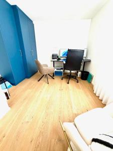 een kantoor met een bureau en een computer op een houten vloer bij Am apartment in Pristina +2 foto's