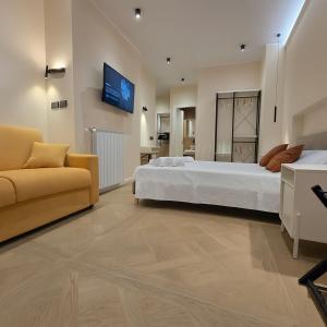 een grote slaapkamer met een bed en een bank bij Centro & Mare 2 Essential - Rooms - Garage in Termoli