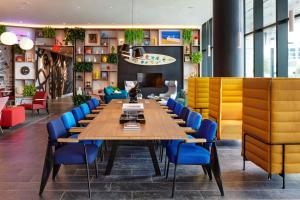 a conference room with a long table and blue chairs at citizenM Miami Worldcenter in Miami