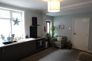 a kitchen with a star on the window and a chair at Victorian Suites - Spacious 2 Bed Apartment in Southport