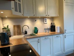 Una cocina con gabinetes blancos y un fregadero. en Apartament Pruszków II, en Pruszków