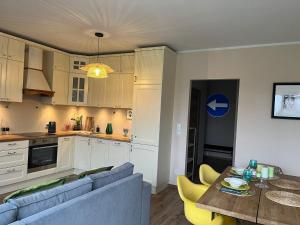 Una cocina y una sala de estar con un sofá y una mesa. en Apartament Pruszków II, en Pruszków