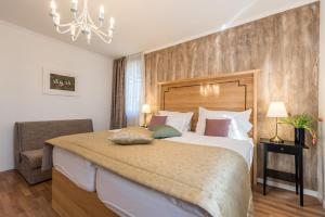 普利特维采村Plitvice Falls Cottage - Luxury rooms & Dinner的一间带大床和吊灯的卧室