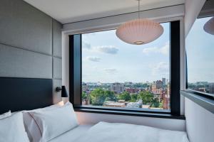 a bedroom with a large window with a city view at citizenM Boston Back Bay in Boston