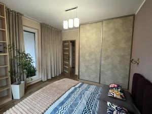Un dormitorio con una cama grande y una ventana. en Apartament Pruszków II, en Pruszków