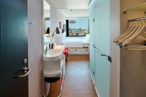 a bathroom with a sink and a bed with a window at citizenM Boston Back Bay in Boston +47 photos