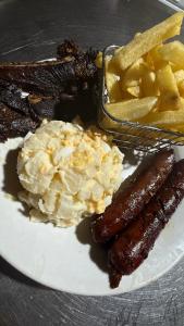 White Sandy Beach Dive Resort في Naviti Island: طبق طعام يحتوي على سجق وبطاطس وبطاطس مقلية