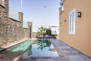 una casa con piscina al lado de un edificio en Zafiro Piscina Climatizada Jacuzzi Barbacoa Vistas al mar, en La Orotava