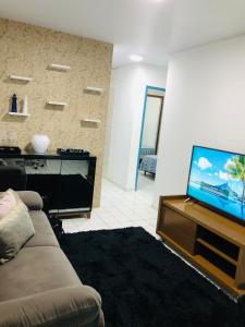 ein Wohnzimmer mit Sofa und Flachbildfernseher in der Unterkunft Home Confort in Garanhuns
