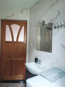 AdamÃ³wDomki całoroczne u Greściaków的带水槽、镜子和马桶的浴室