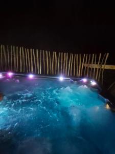 a swimming pool at night with lights in it at Vertu'Ose in Morbier