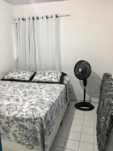 Schlafzimmer mit einem Bett und einem Ventilator in der Unterkunft Home Confort in Garanhuns