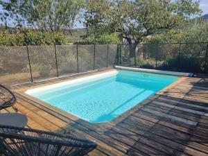 einen Pool auf einer Holzterrasse mit einem Zaun in der Unterkunft Villa Caroux in Bédarieux