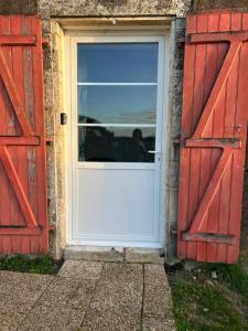 マランにあるLa maison du bonheurの赤いドアのあるレンガ造りの家にある白いドア