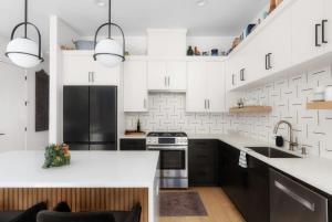 a kitchen with white cabinets and black appliances at Central Austin Oasis with Pool - Sleeps 9 in Austin +17 photos