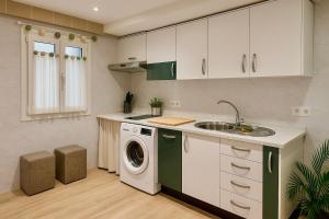 a kitchen with a washing machine and a sink at Tu hogar en Sevilla in Seville