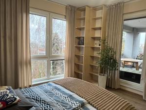 Un dormitorio con una cama y dos ventanas en Apartament Pruszków II, en Pruszków