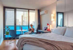 una habitación de hotel con una cama y dos mujeres sentadas en sillas en Panorama Cental Hotel Batumi, en Batumi