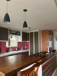 eine Küche mit Holzarbeitsplatte und roten Fliesen in der Unterkunft CasaRiva in Biguaçu